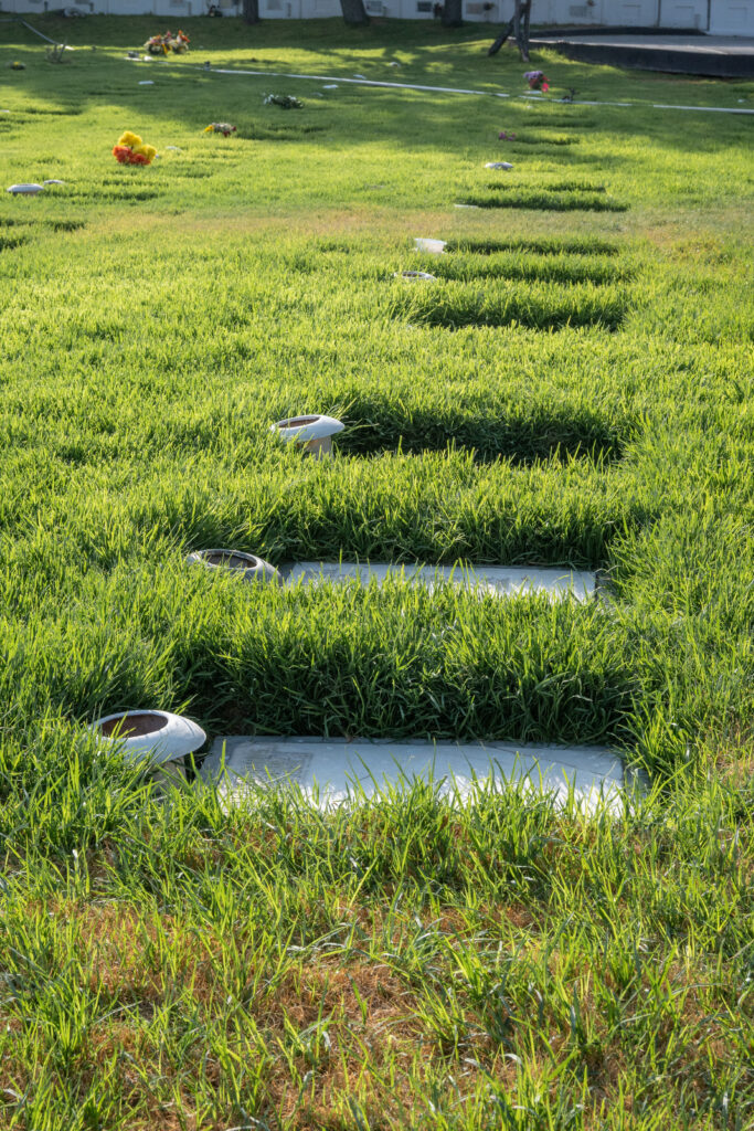 Several flat headstones in a graveyard